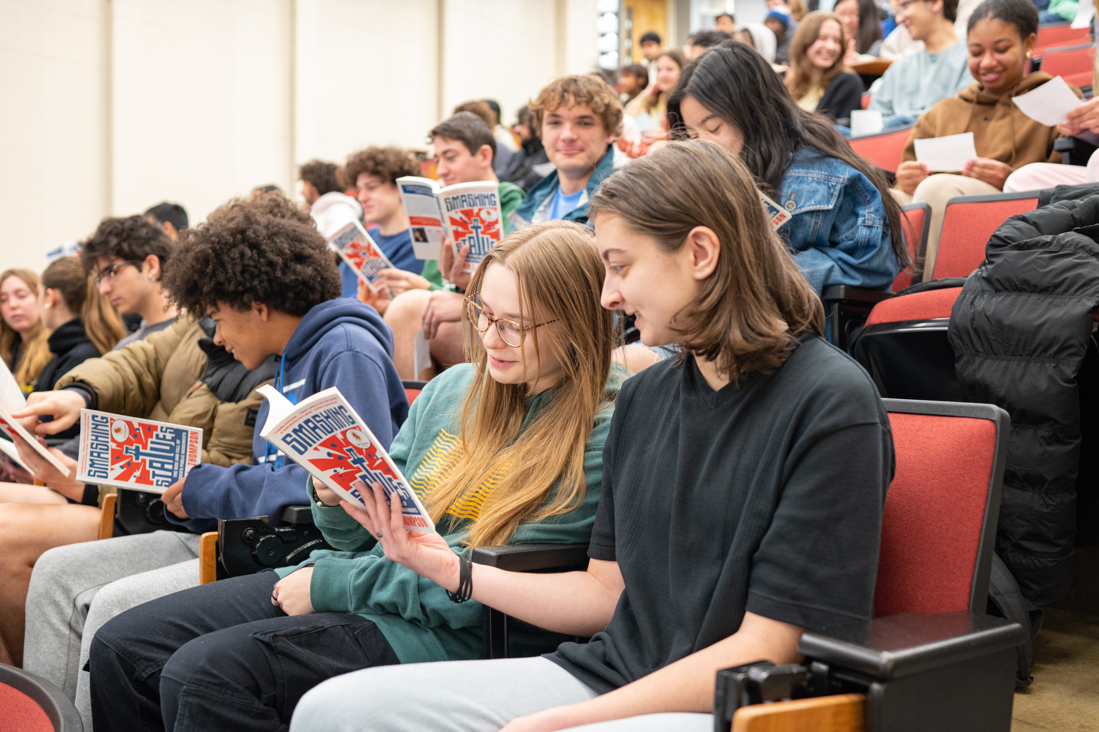 students in lecture hall with books open