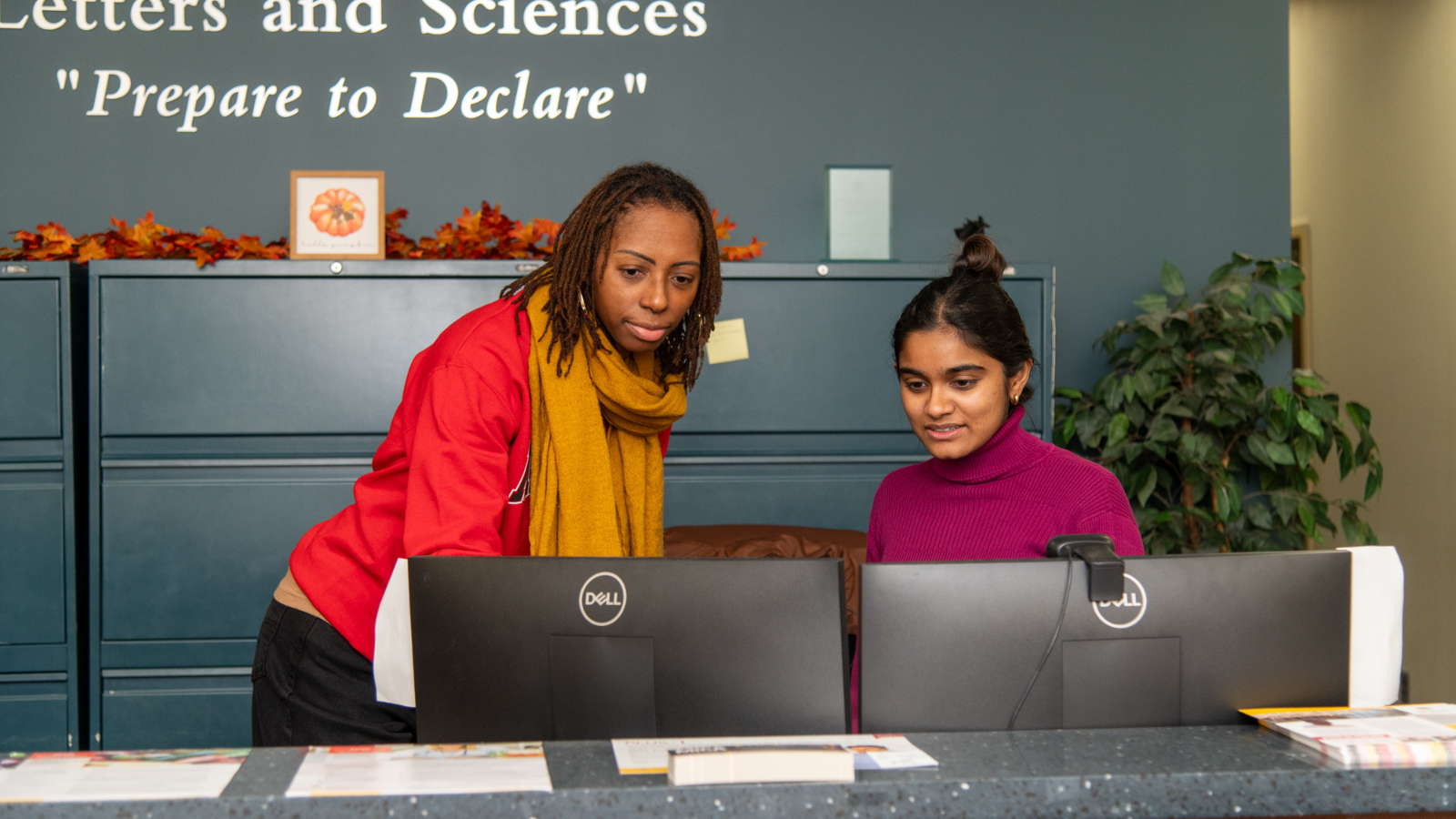 advisors lean over computer