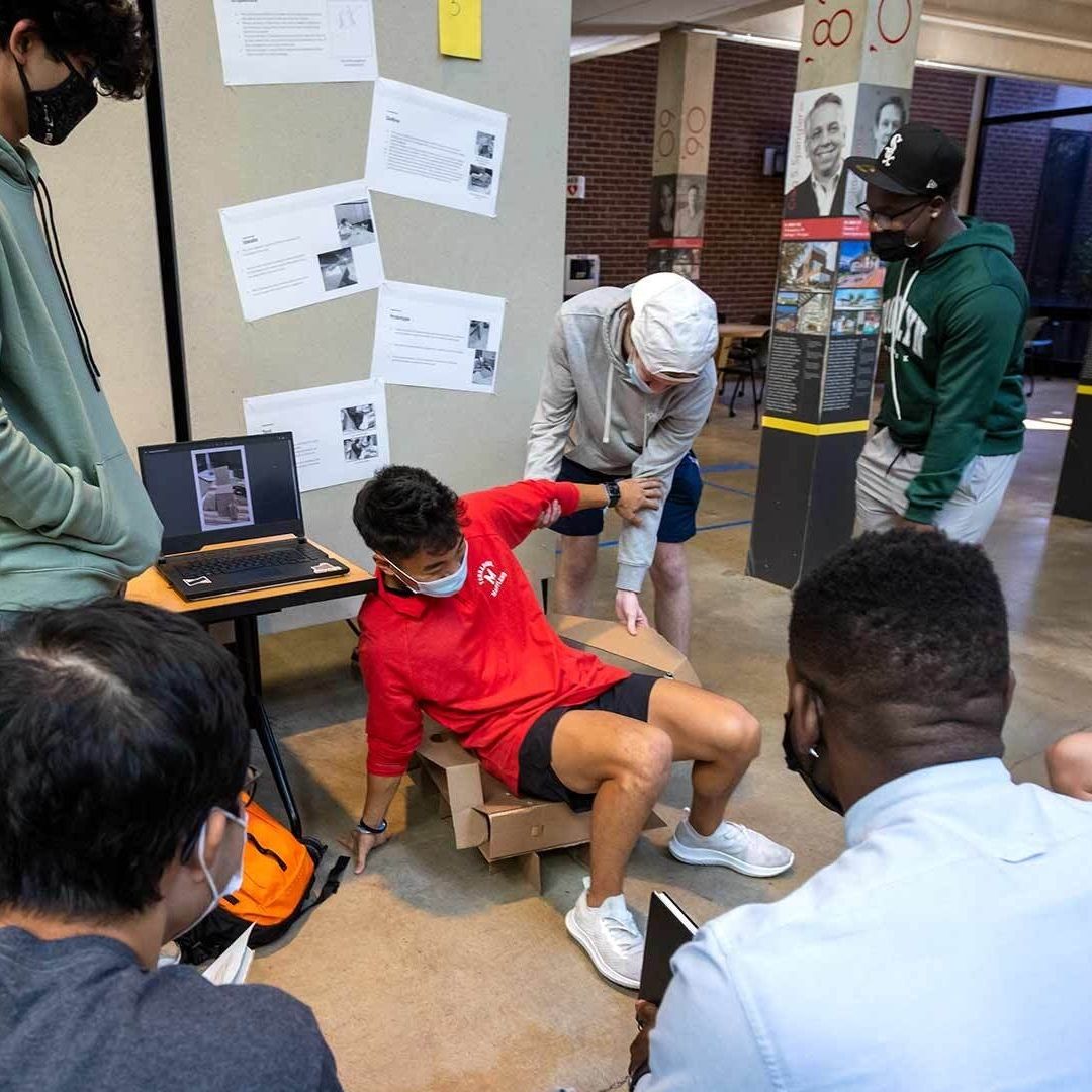 students testing cardboard chair design