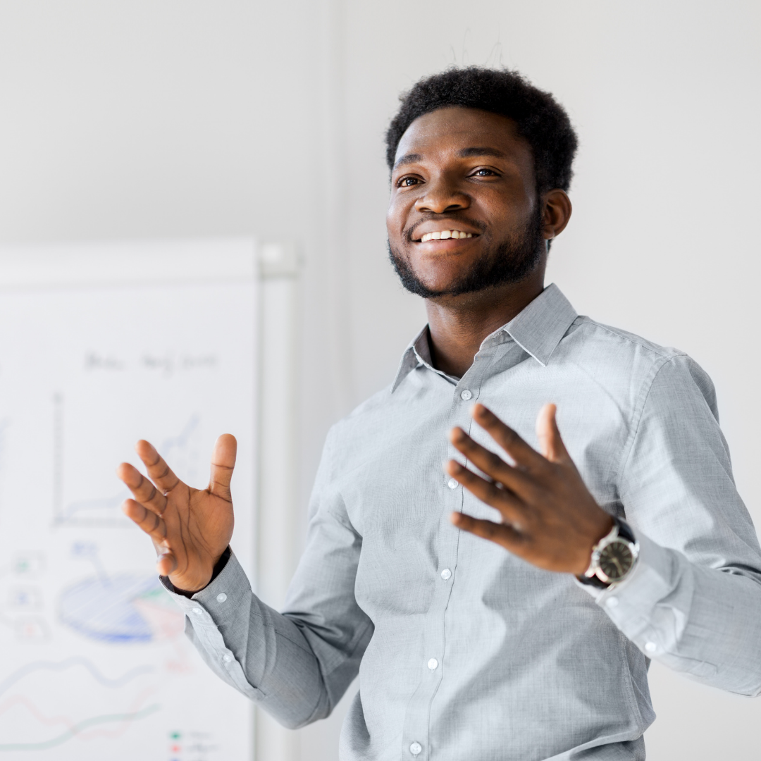 student stands in front of presentation board, with arms out