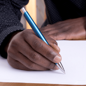 hands holding pen writing on paper